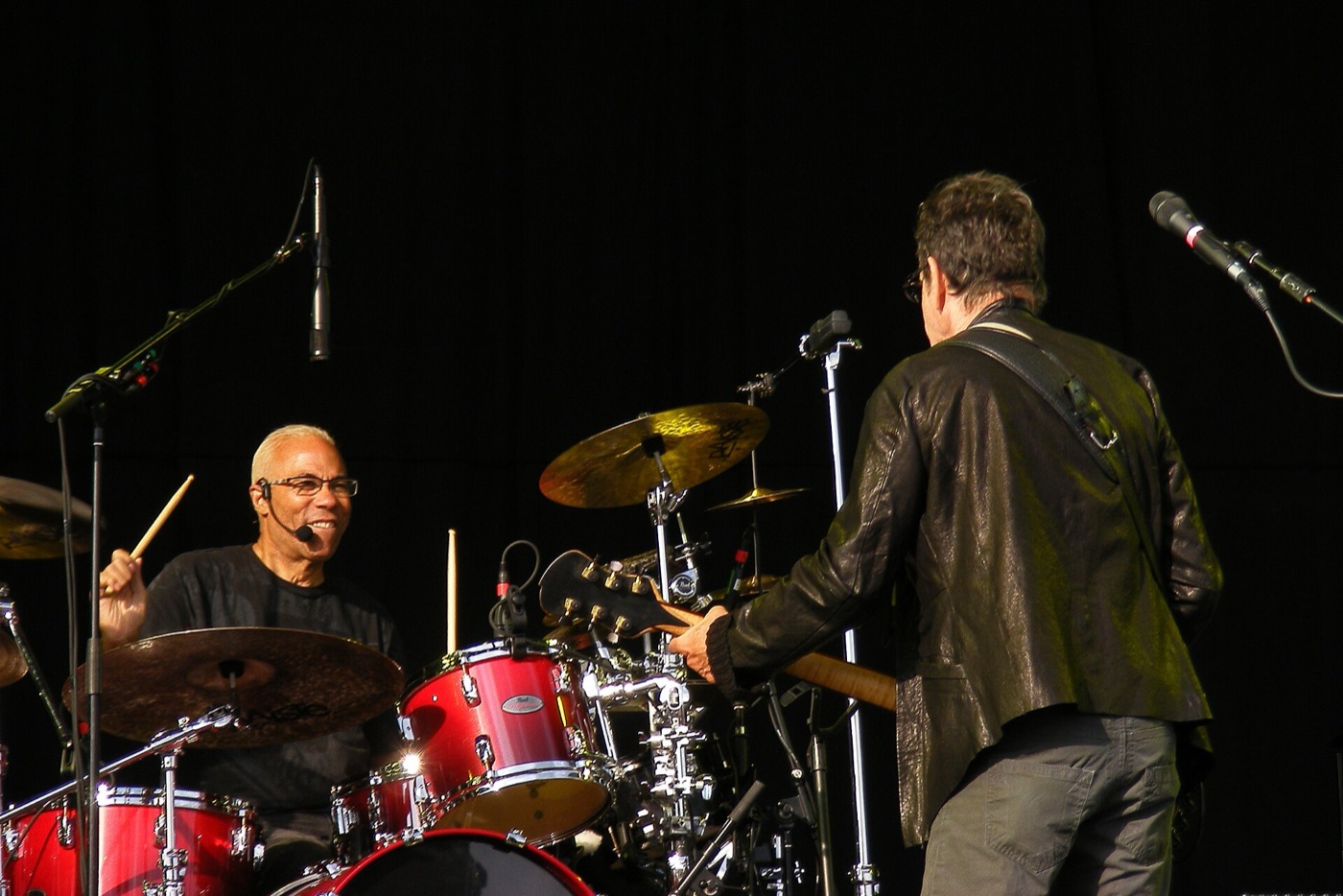 Tony “Thunder” Smith at the drums behind Lou Reed, on an outdoor stage.